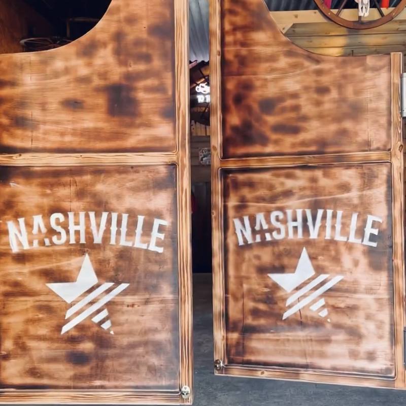 Scorched wooden saloon doors branded with the Nashville star logo
